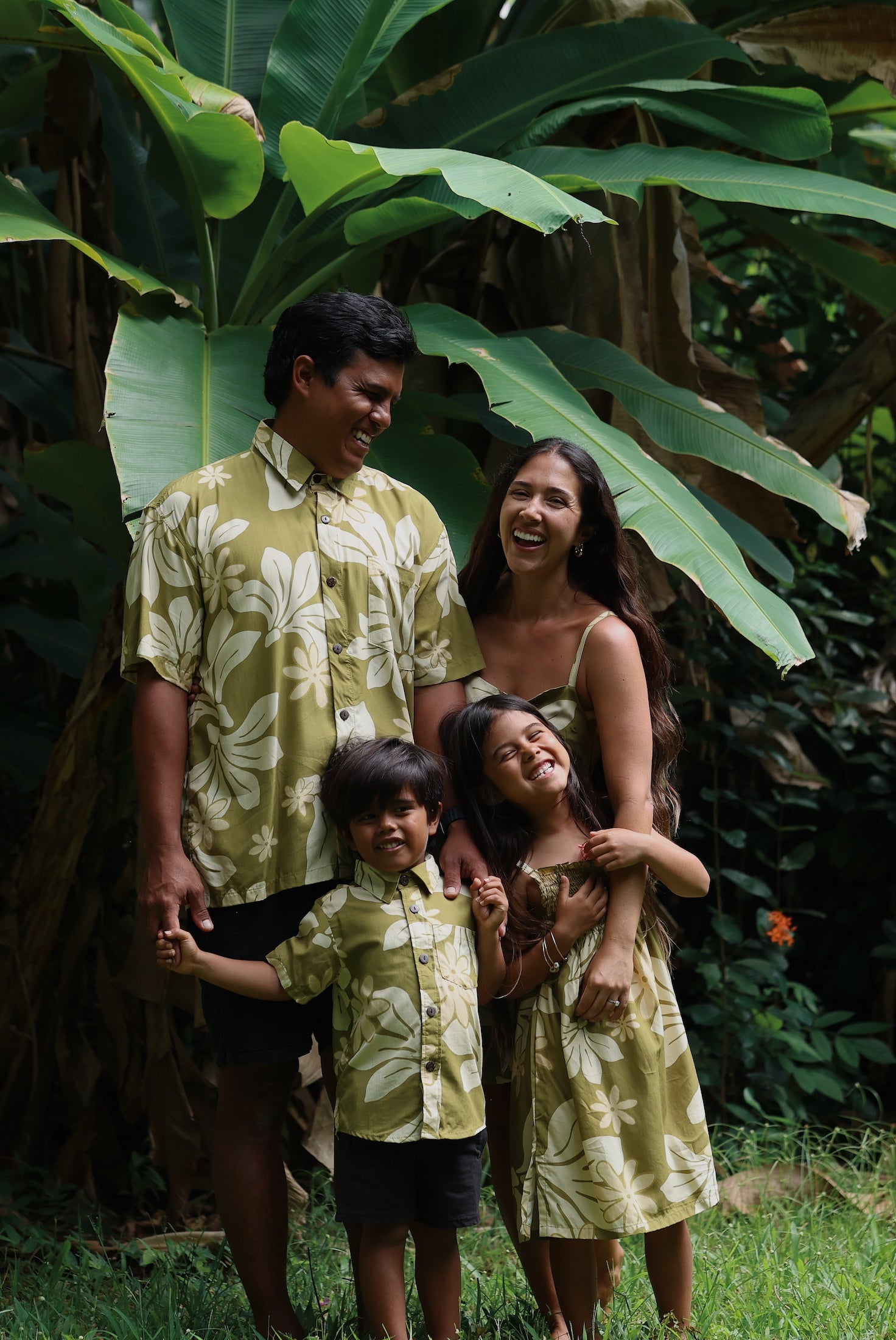family wearing matching aloha wear in green print with naupaka pattern