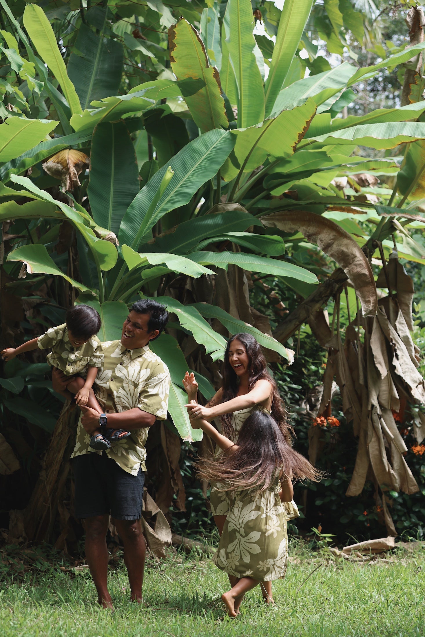 family wearing matching aloha wear in green print with naupaka pattern