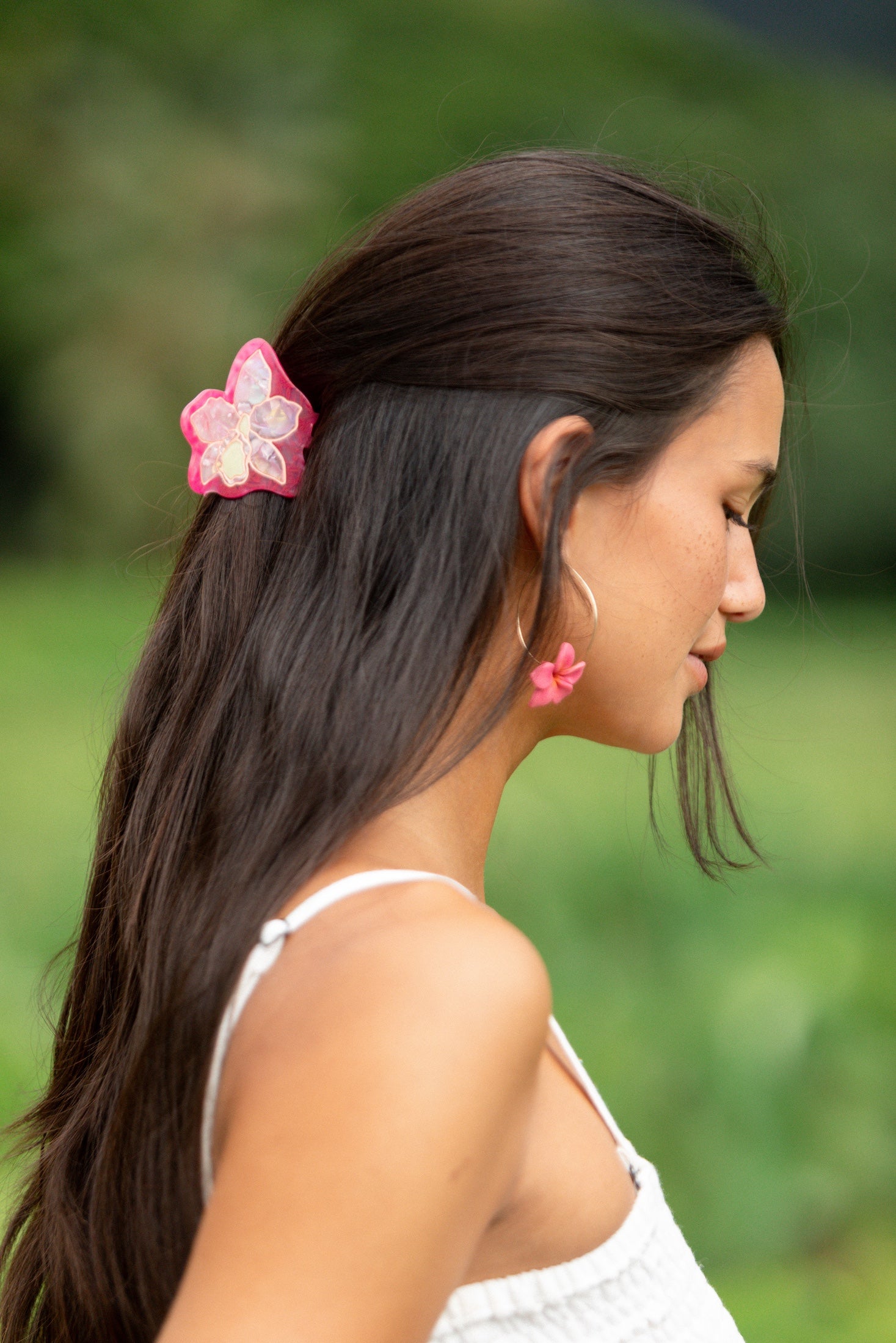 woman wearing a small pink and peach orchid hairclip in hair