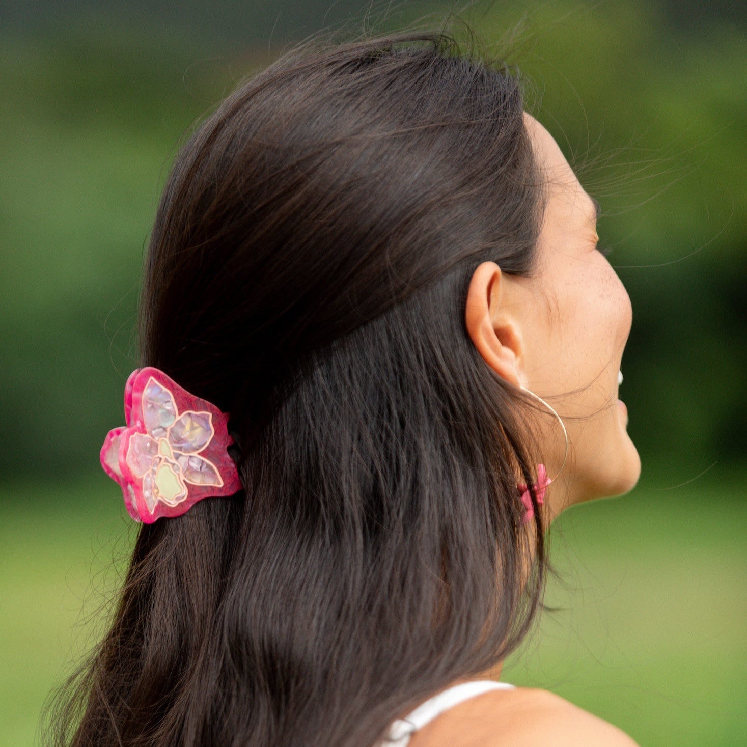 woman wearing a small pink and peach orchid hairclip in hair