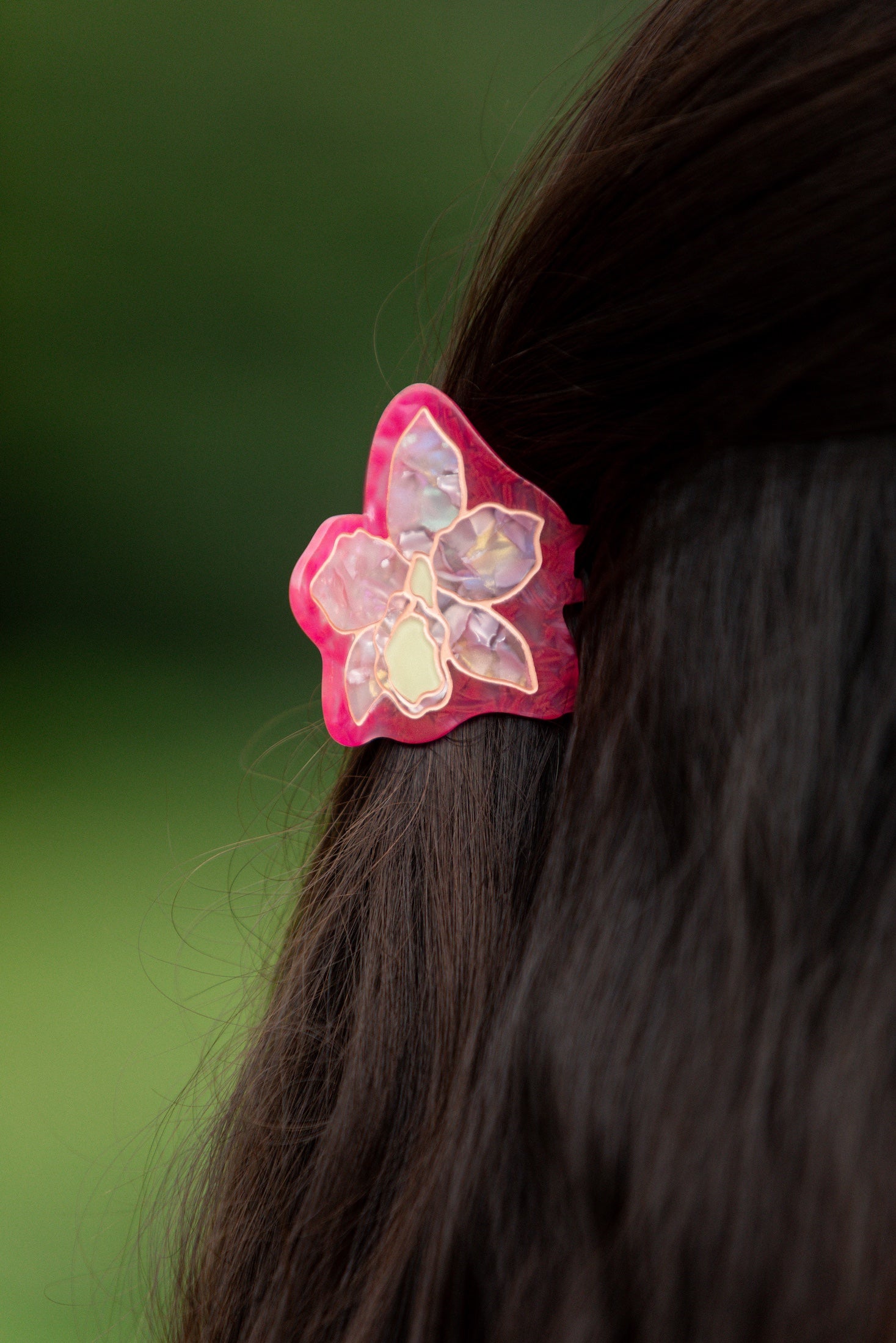 woman wearing a small pink and peach orchid hairclip in hair