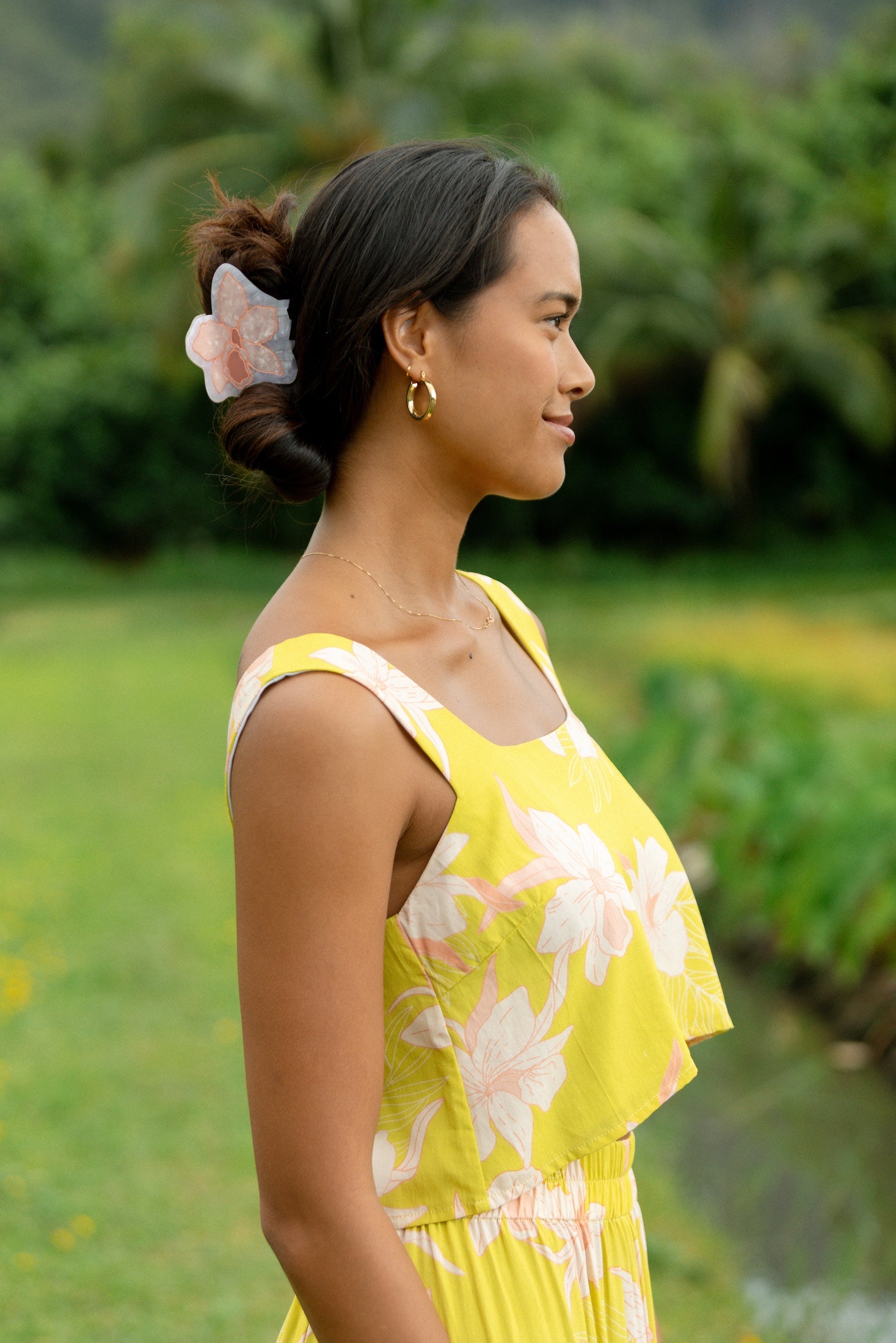 woman wearing a large peach and white orchid hair clip in hair