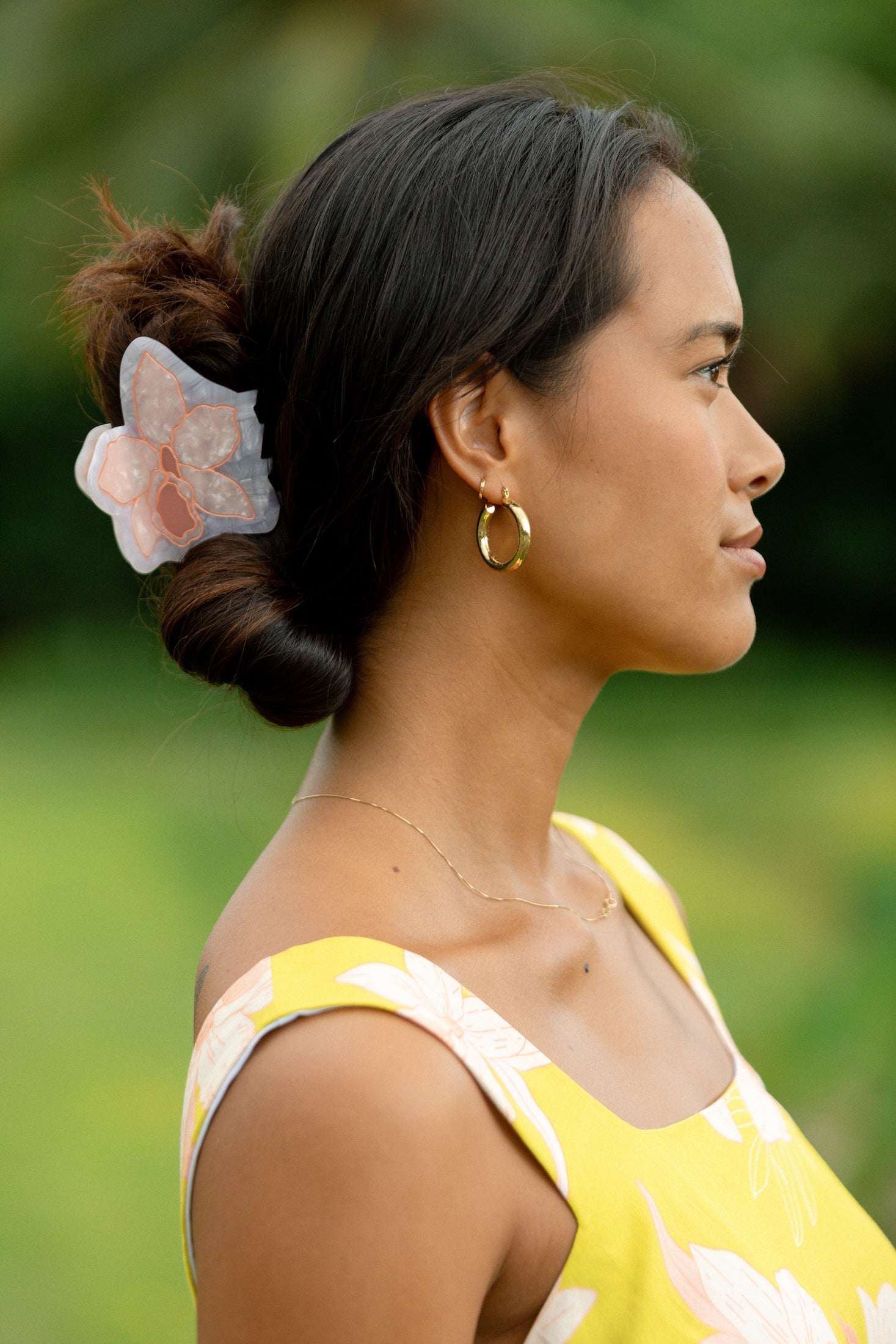 woman wearing a large peach and white orchid hair clip in hair