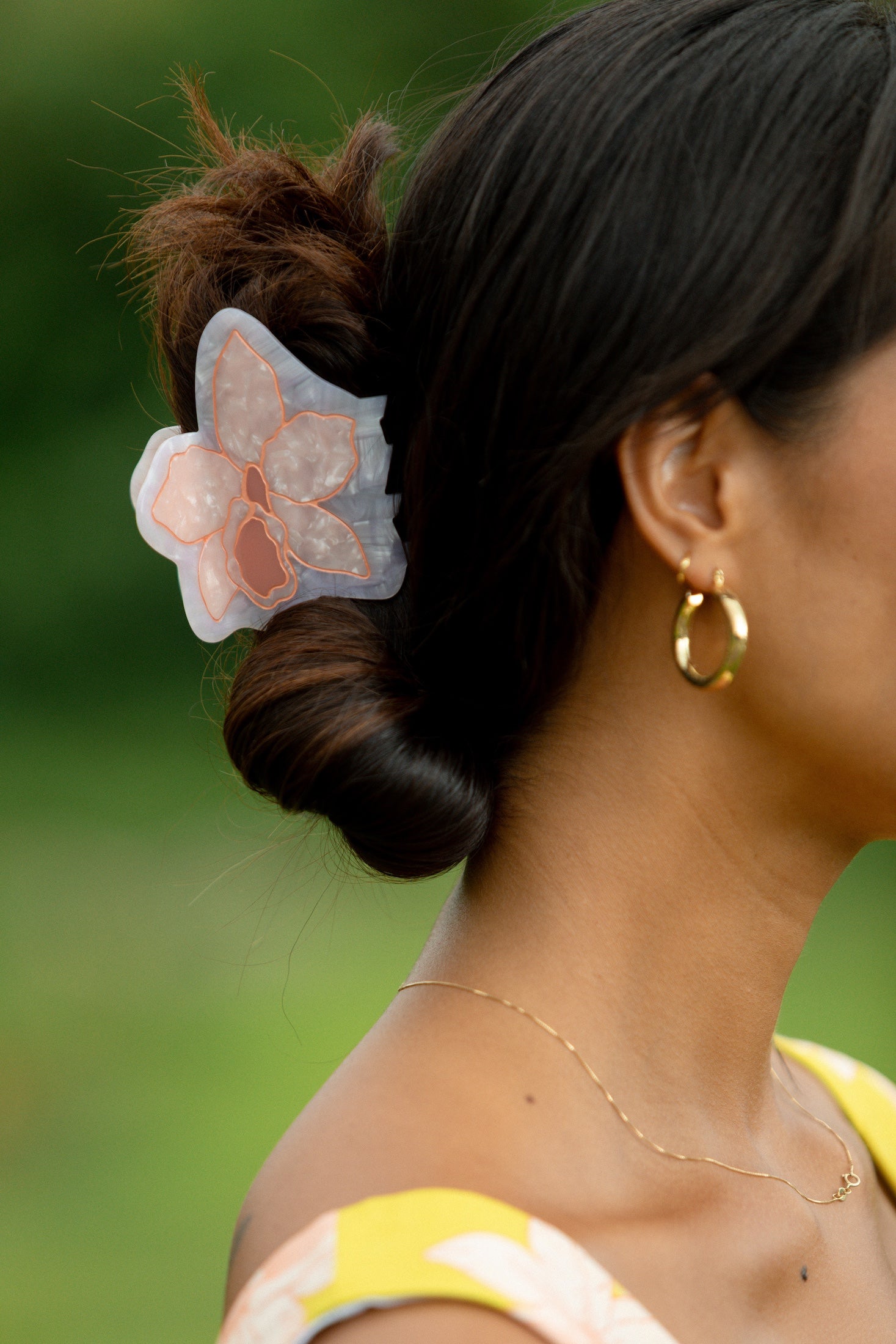 woman wearing a large peach and white orchid hair clip in hair