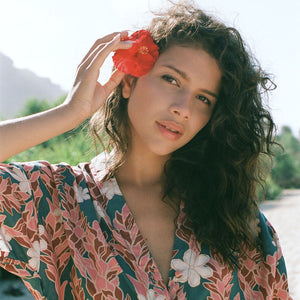 woman with brown hair wearing button up dress with red ginger and tiare print