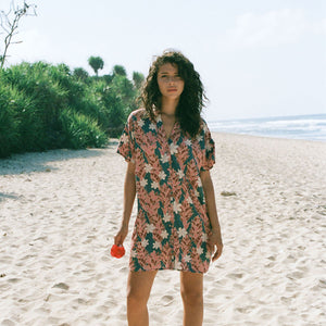 woman with brown hair wearing button up dress with red ginger and tiare print