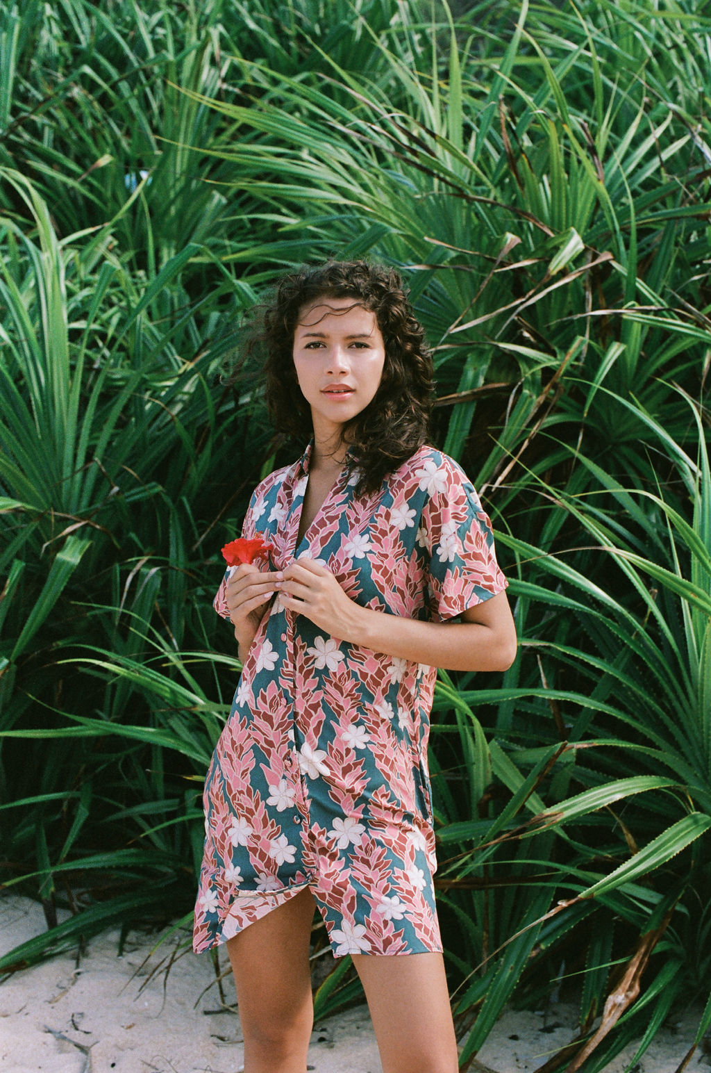 woman with brown hair wearing button up dress with red ginger and tiare print