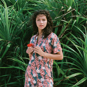woman with brown hair wearing button up dress with red ginger and tiare print