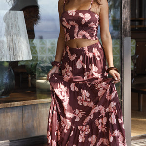 woman wearing brown maxi skirt with light pink lei awapuhi print