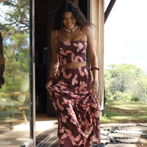 woman wearing brown maxi skirt with light pink lei awapuhi print