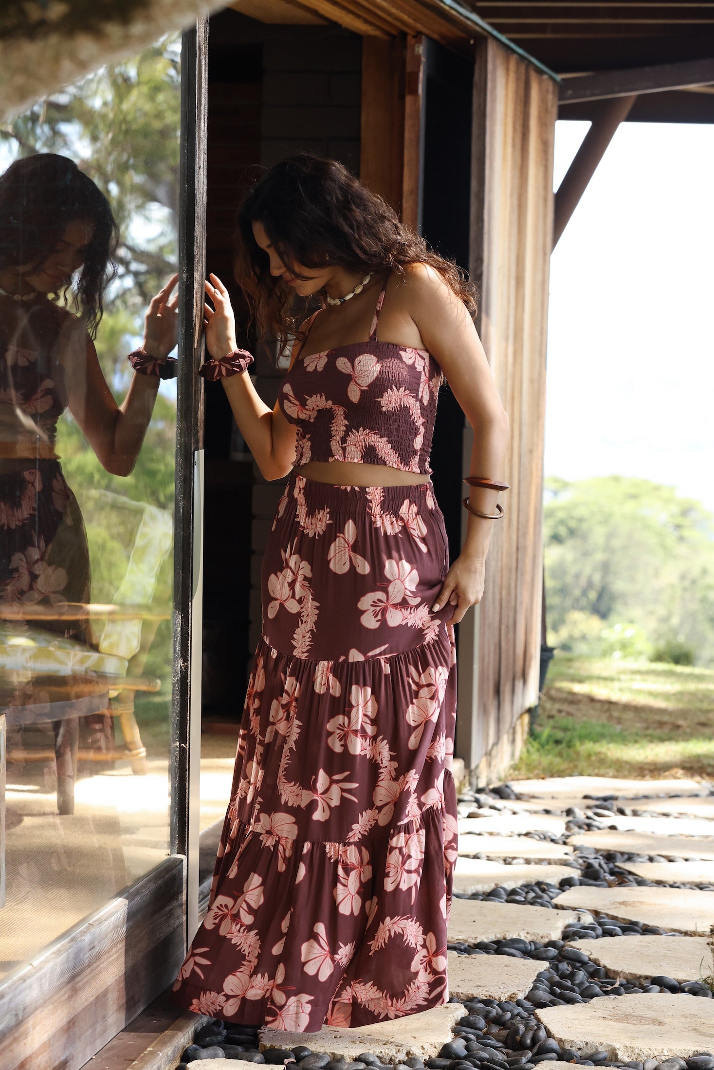 woman wearing brown maxi skirt with light pink lei awapuhi print
