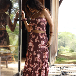 woman wearing brown maxi skirt with light pink lei awapuhi print
