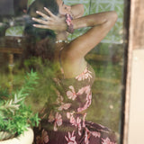 woman wearing mauve scrunchie with lei awapuhi print in hair
