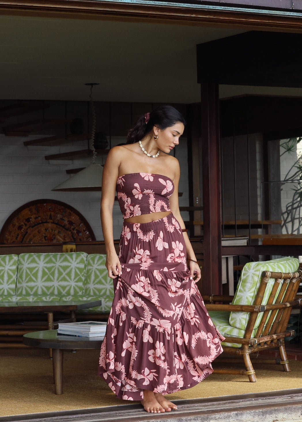 woman wearing brown maxi skirt with light pink lei awapuhi print