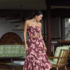 woman wearing brown maxi skirt with light pink lei awapuhi print