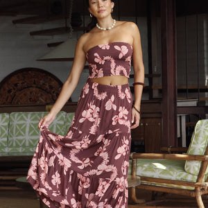 woman wearing brown maxi skirt with light pink lei awapuhi print