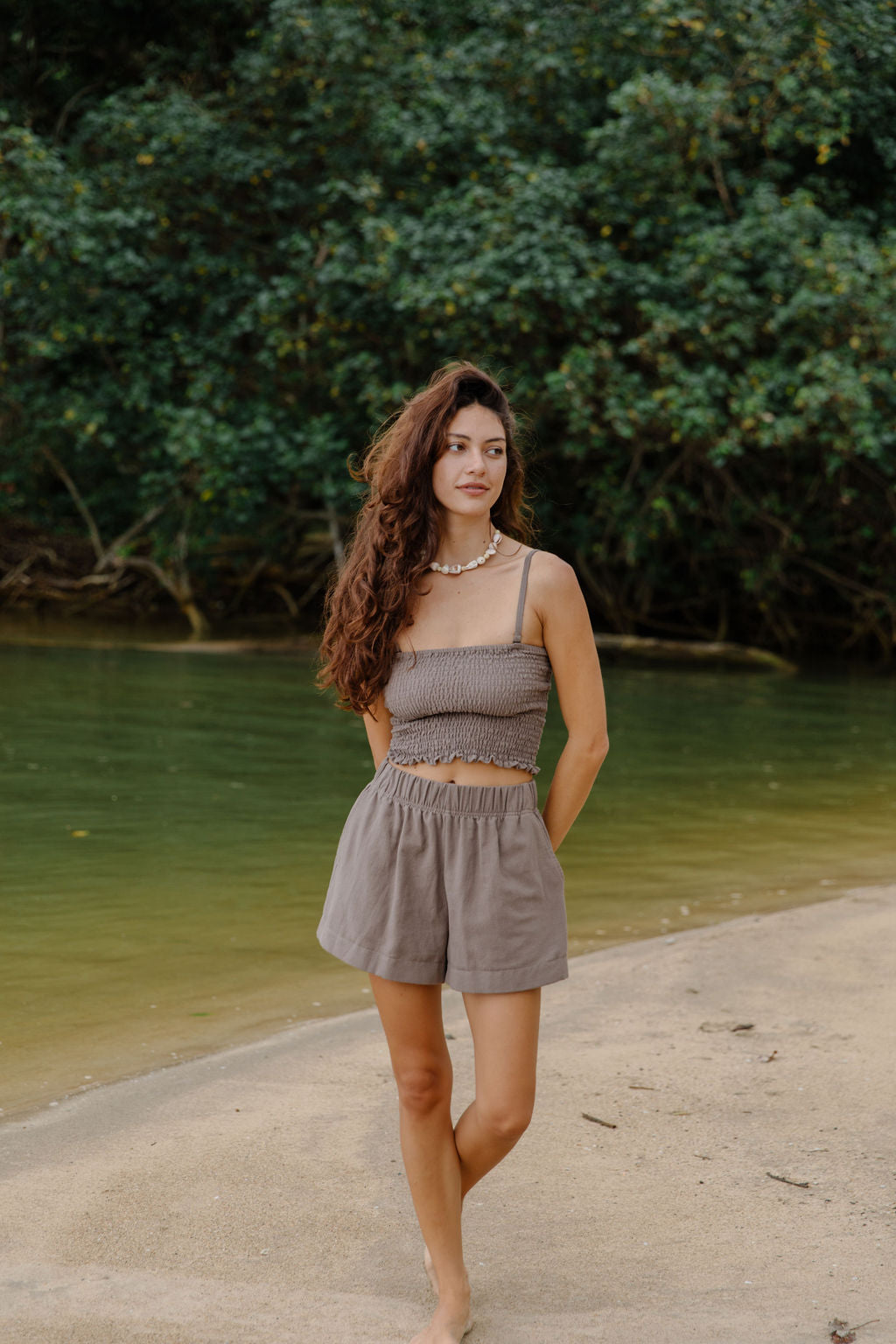 Woman wearing smocked tube top with spaghetti straps and short in medium brown linen.