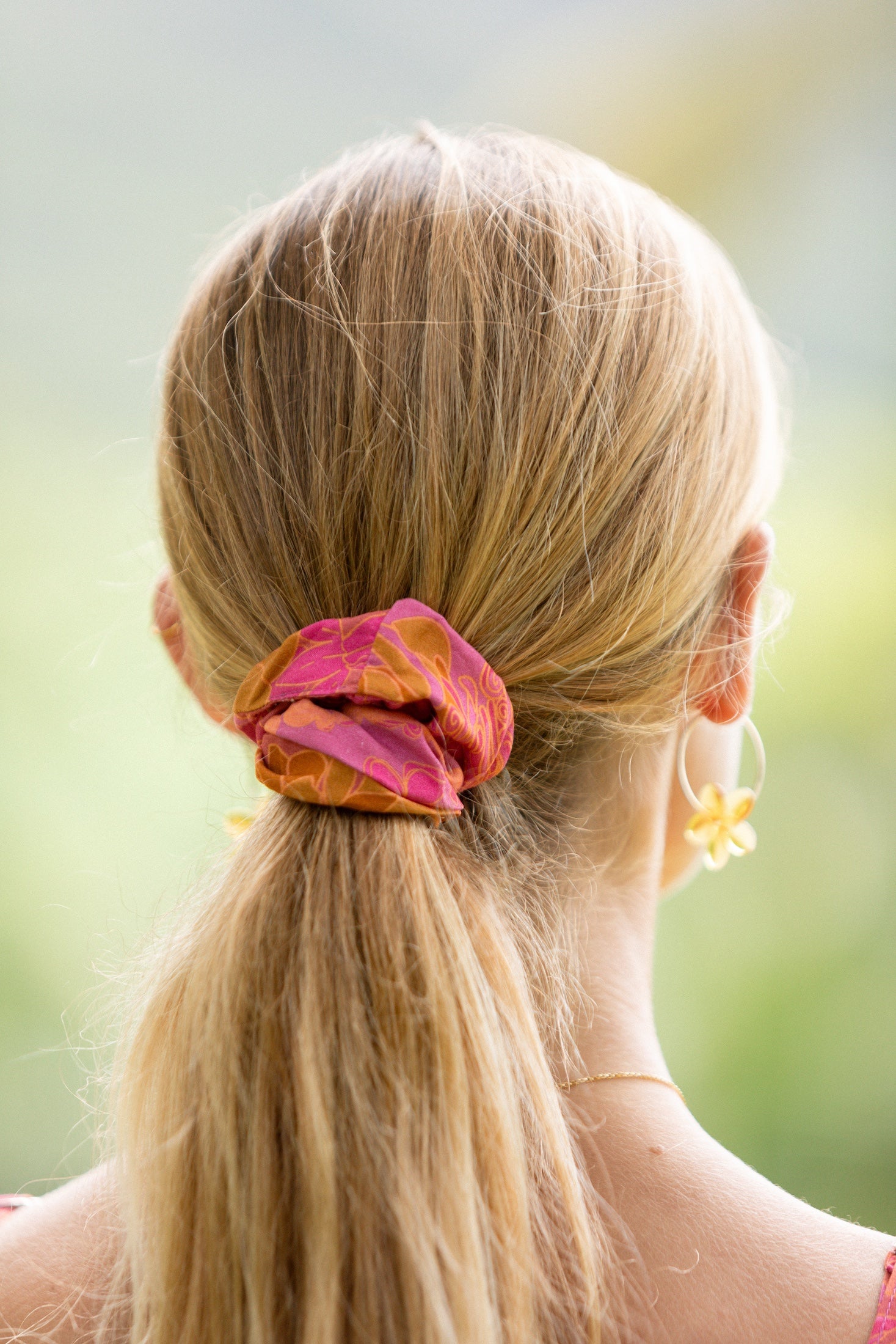 woman wearing pink scrunchie with lei day print