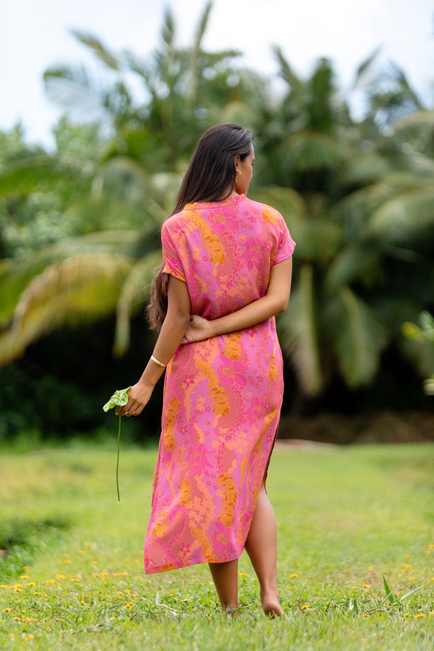 woman wearing a pink v neck maxi dress with lei print