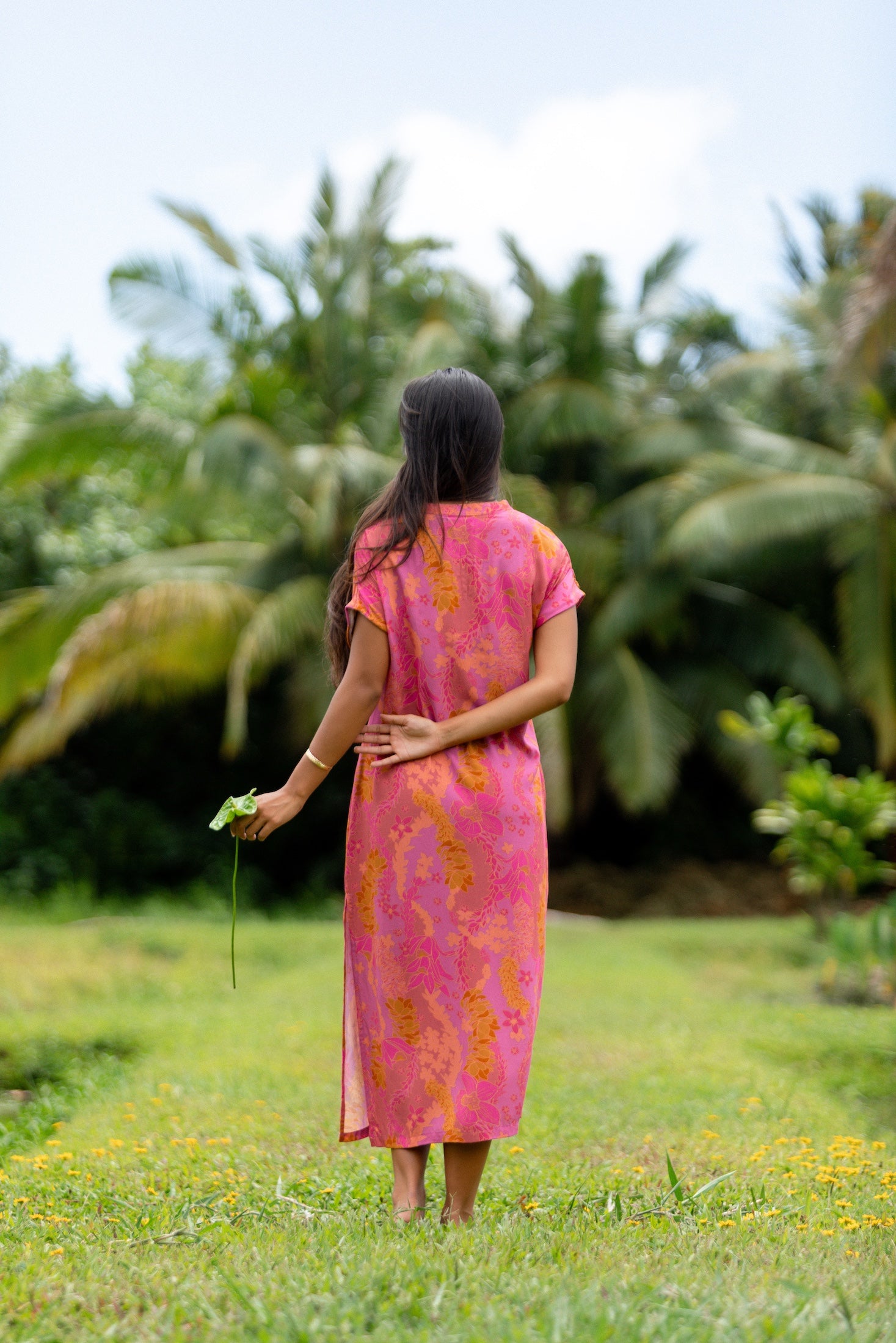 woman wearing a pink v neck maxi dress with lei print