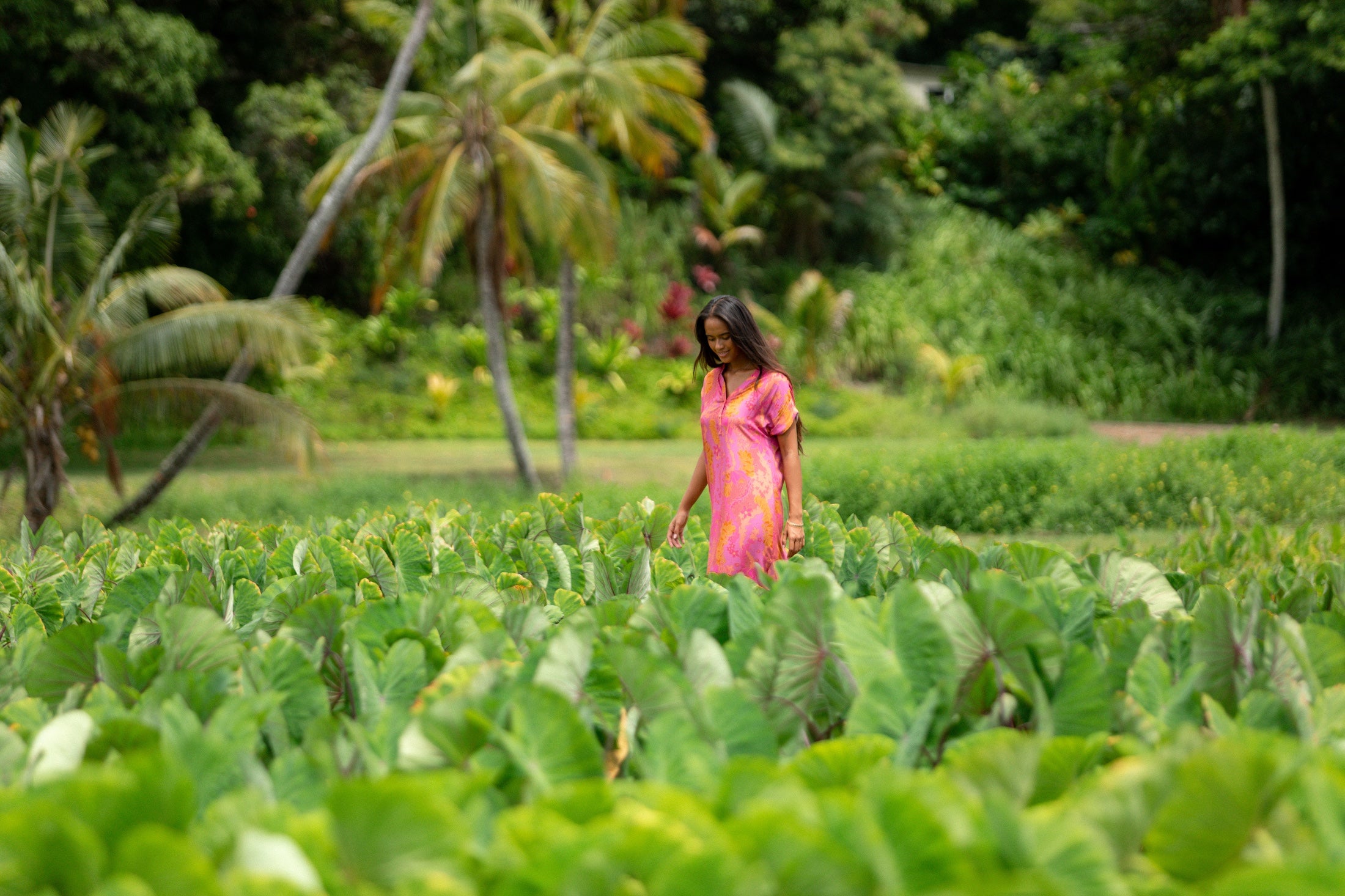 woman wearing a pink v neck maxi dress with lei print