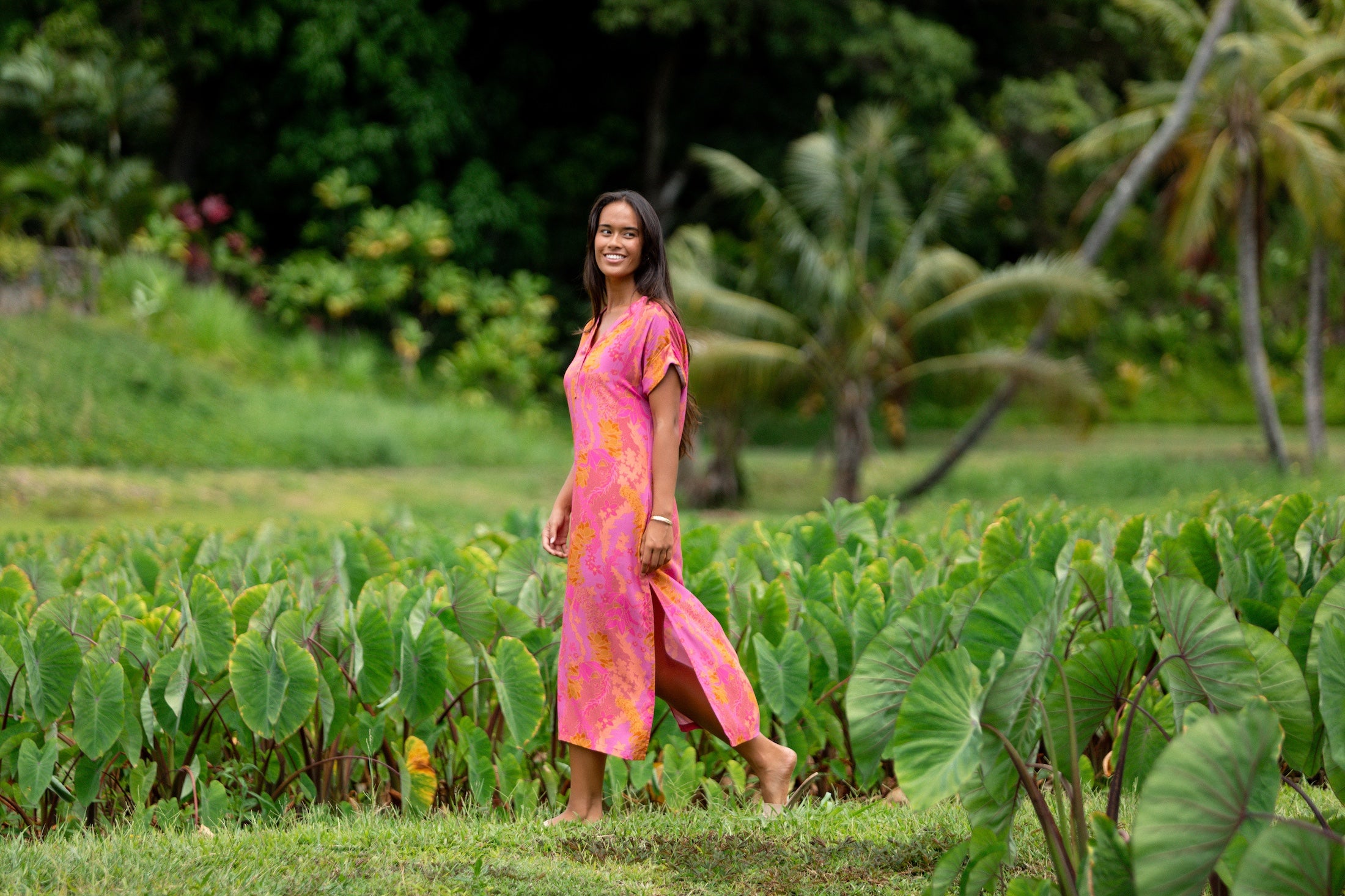 woman wearing a pink v neck maxi dress with lei print