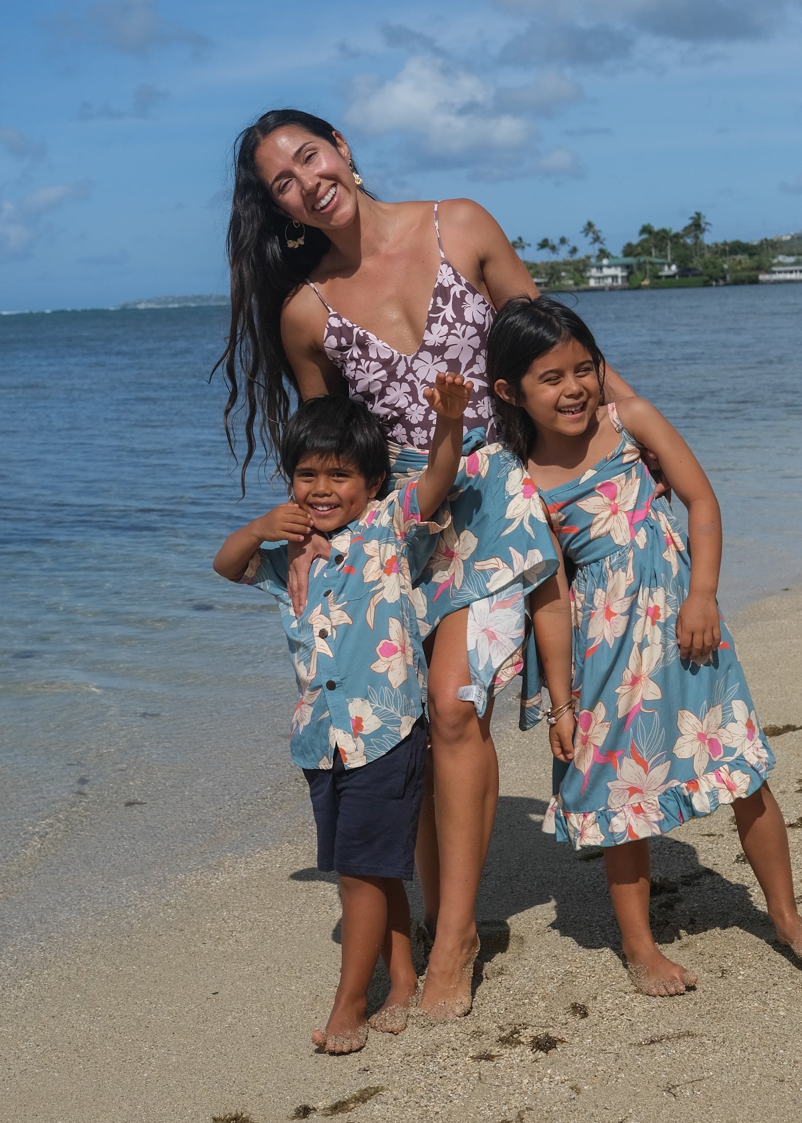 little girl wearing a teal flowy dress with cream colored orchid pattern