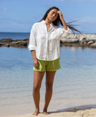 The YIREH A La Mode Button-Up in Cloud is a linen, slightly oversized, long-sleeve button-up featuring mother-of-pearl shell buttons. - w/ Parakeet Millie Short