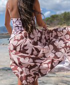 woman with brown hair wearing a pareo with blush pink and brown hibiscus print 