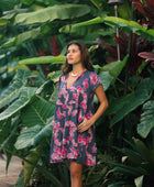 Woman wearing dress in navy with pink ginger and lei print.