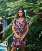 Woman wearing dress in navy with pink ginger and lei print.