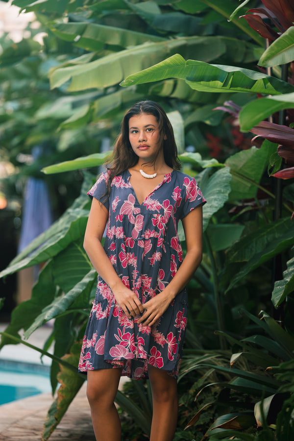 Woman wearing dress in navy with pink ginger and lei print.