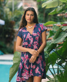 Woman wearing dress in navy with pink ginger and lei print.