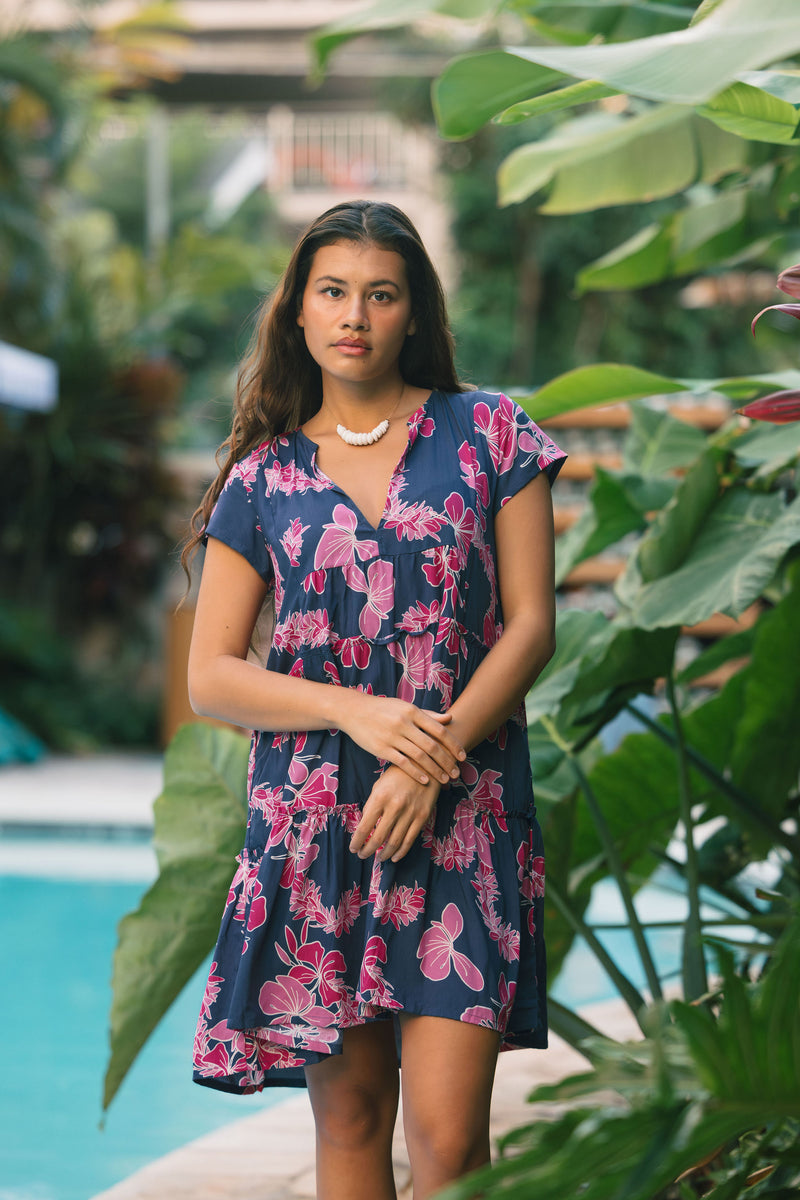 Woman wearing dress in navy with pink ginger and lei print.