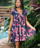 Woman wearing dress in navy with pink ginger and lei print.