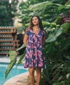 Woman wearing dress in navy with pink ginger and lei print.