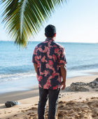 Man in button up shirt with dark navy ground and pink ginger and lei.