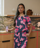 Woman wearing top and pants in navy with pink ginger and lei print.