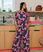 Woman with top and pants in navy with pink ginger and lei print.