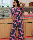 Woman wearing top and pants in navy with pink ginger and lei print.