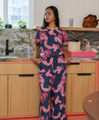 Woman with top and pants in navy with pink ginger and lei print.