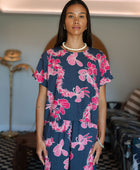 Woman wearing top and pants in navy with pink ginger and lei print.