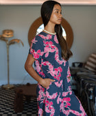 Woman wearing top and pants in navy with pink ginger and lei print.