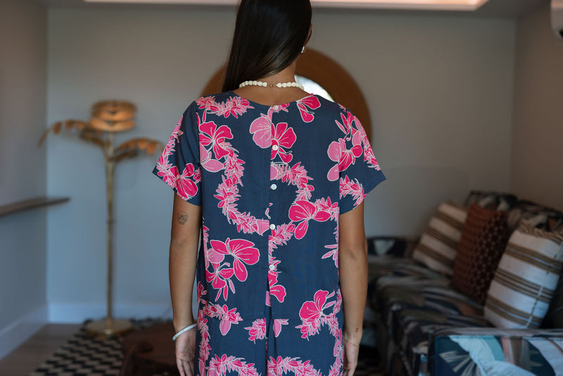 Woman wearing top and pants in navy with pink ginger and lei print.