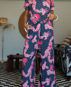 Woman with top and pants in navy with pink ginger and lei print.