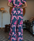 Woman with top and pants in navy with pink ginger and lei print.