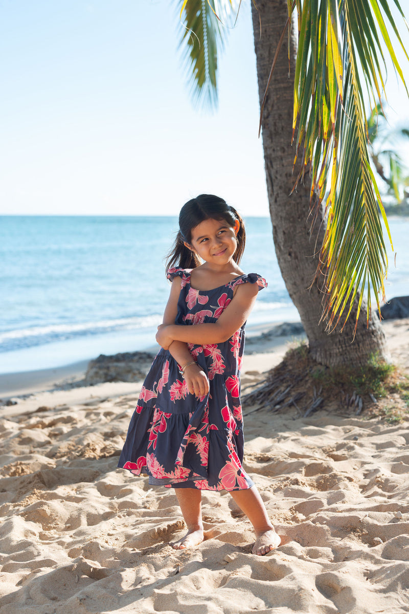 Girl in dress with dark navy ground and pink ginger and lei.