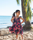 Girl in dress with dark navy ground and pink ginger and lei.