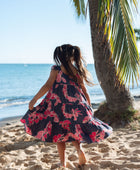 Girl in dress with dark navy ground and pink ginger and lei.