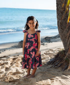 Girl in dress with dark navy ground and pink ginger and lei.